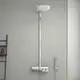 Duschsystem von Ideal Standard mit einer großen Kopfbrause, einer Handbrause, Steuerungstasten und einer Ablagefläche, montiert an einer Wand.
